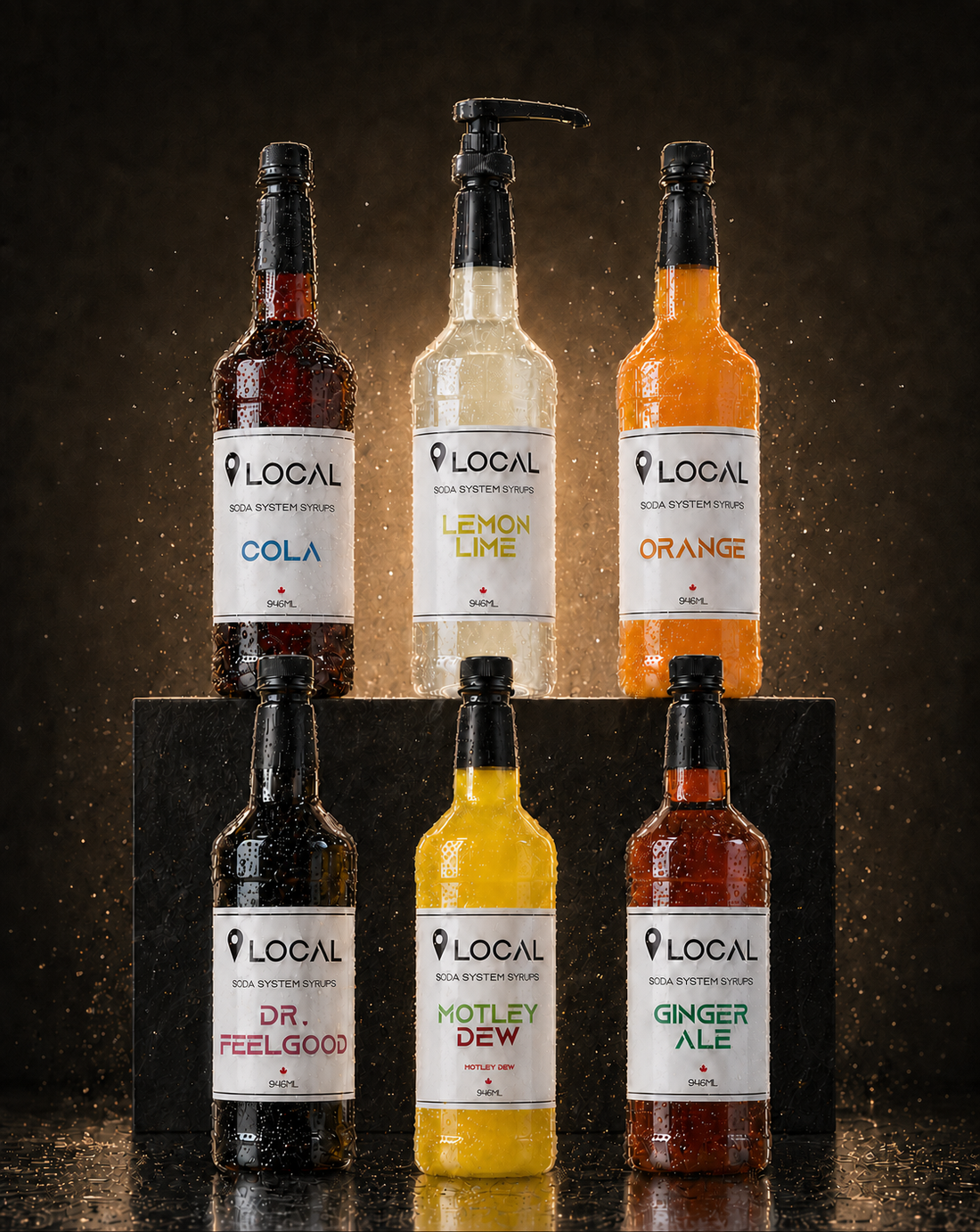 Six LOCAL soda system syrup bottles on a dark studio backdrop: cola, lemon lime, orange, Dr. Feelgood, Motley Dew and ginger ale